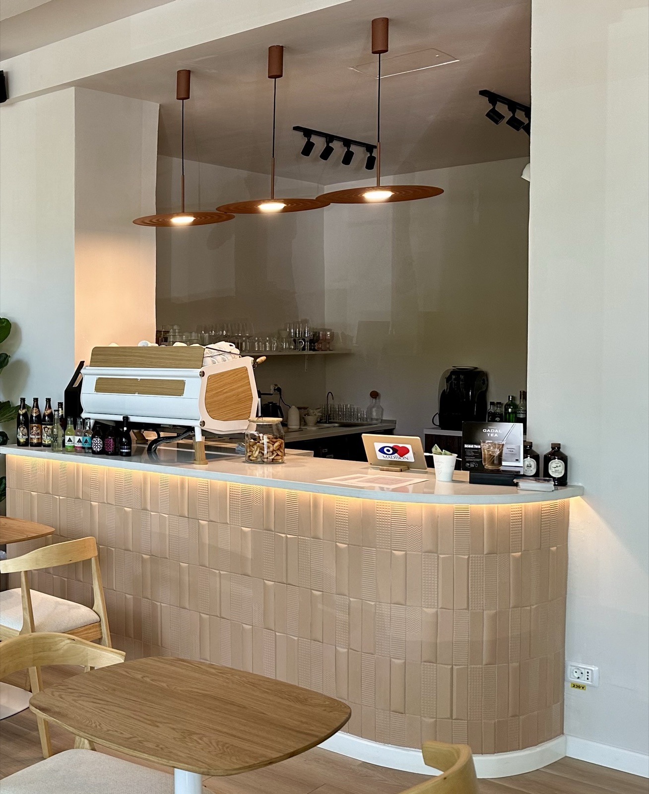 Barul PARTIcULAR, cu espressorul alb, lămpi suspendate din lemn și blat luminat